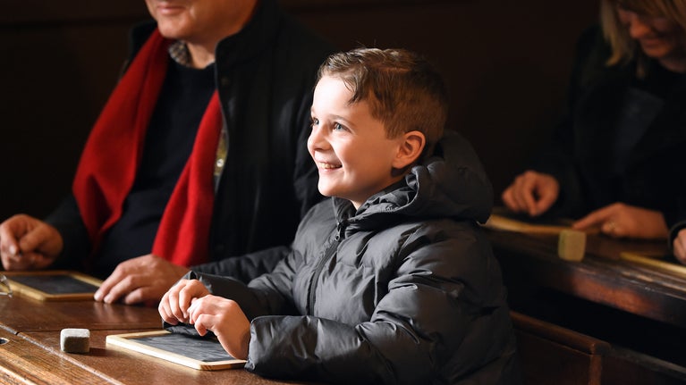 Young boy engaged in Victorian Schoolroom lesson at The Children's Country House